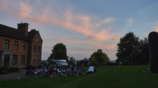 Visitors enjoying an outdoor cinema screening as the sun sets at Chartwell.